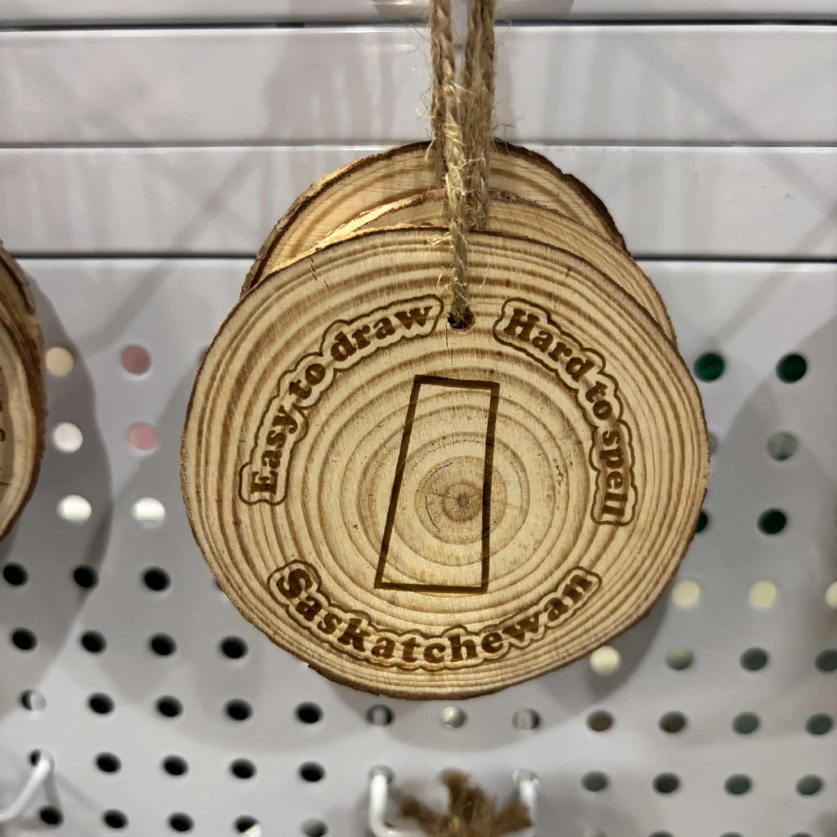 Wood slice Christmas ornament with "Easy to Draw - Hard to Spell" laser-engraved design